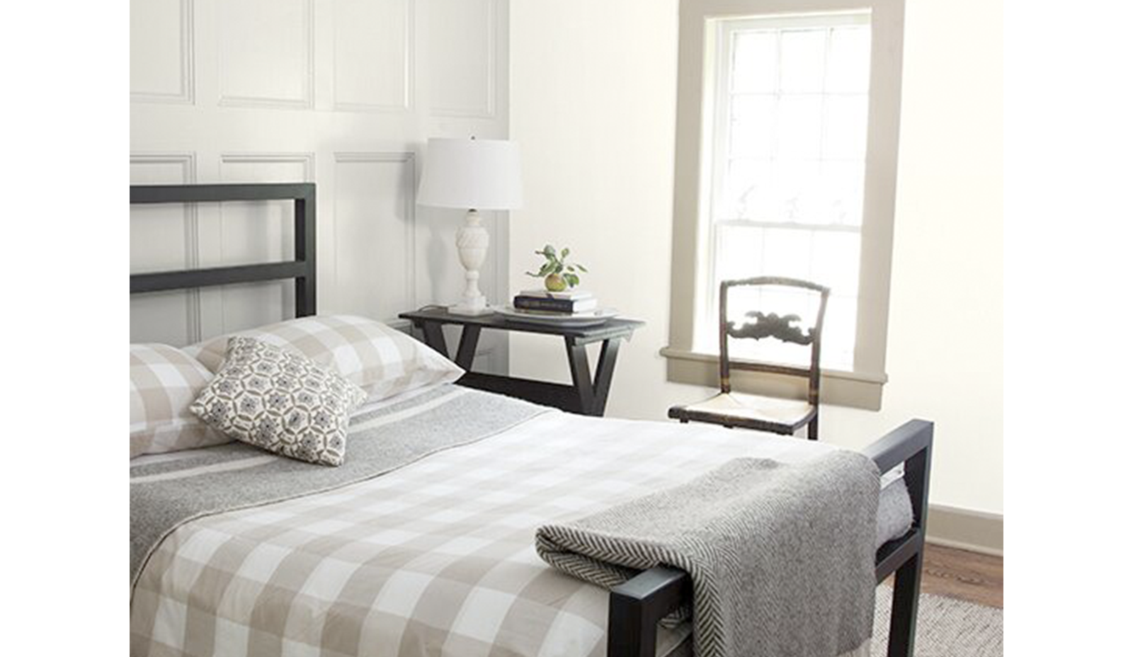 Un dormitorio blanco con paredes paneladas pintadas en Classic Grey OC-23.
